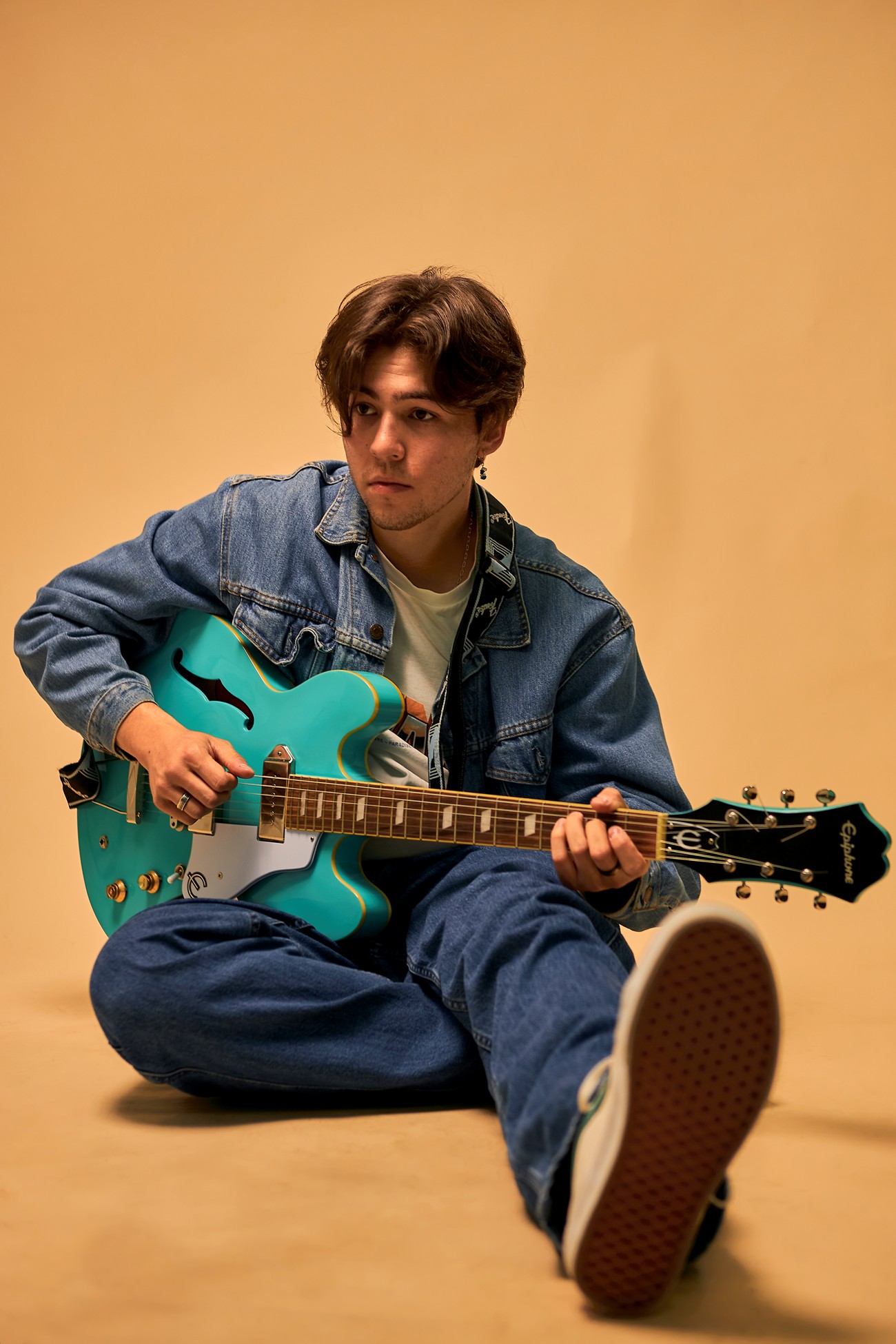 Musician Ignasyo sitting with a blue guitar