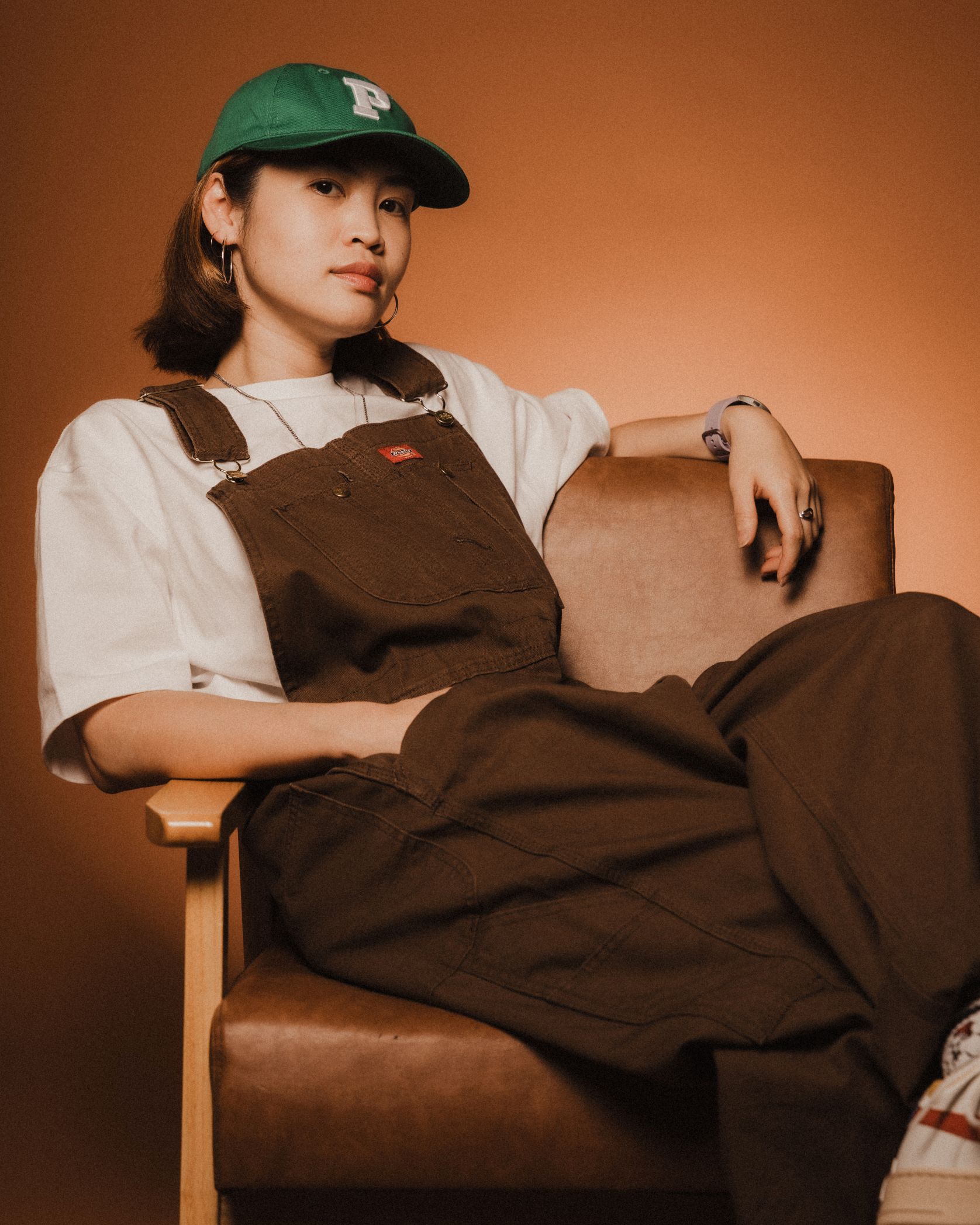 Musician Jade Kenji lounging on a leather chair