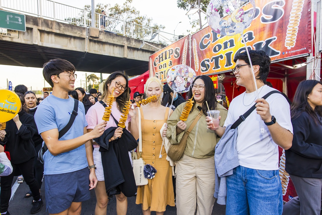 2024 Cabramatta Moon Festival group eating chips on a stick by Anna Kucera