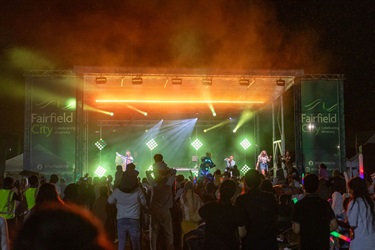 A view of the stage at Illuminate NYE from the crowd showing the stage light up with green lights