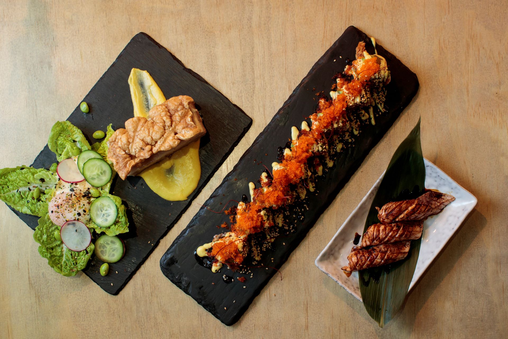 High angle shot of three plates of food each on rectagular shaped plates